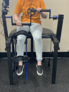 A woman is sitting on a chair with a replacement device.