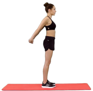 A woman is standing on a red exercise mat, engaging her shoulder muscles.