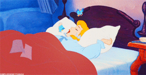 Cinderella sleeping in a comfortable bed with a blue blanket.