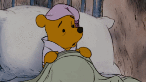 Winnie the pooh peacefully sleeping in bed with a cozy blanket.